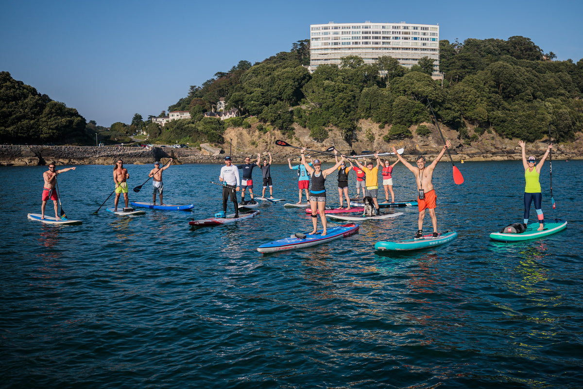 A group of paddleboarders enjoying the water off the English Riviera coast